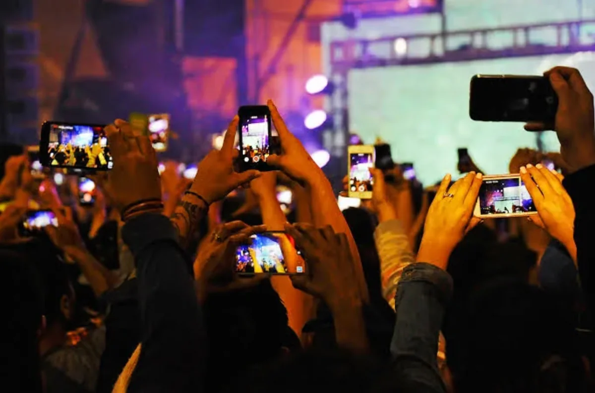 Public filmant un concert avec des dizaines de smartphones levés