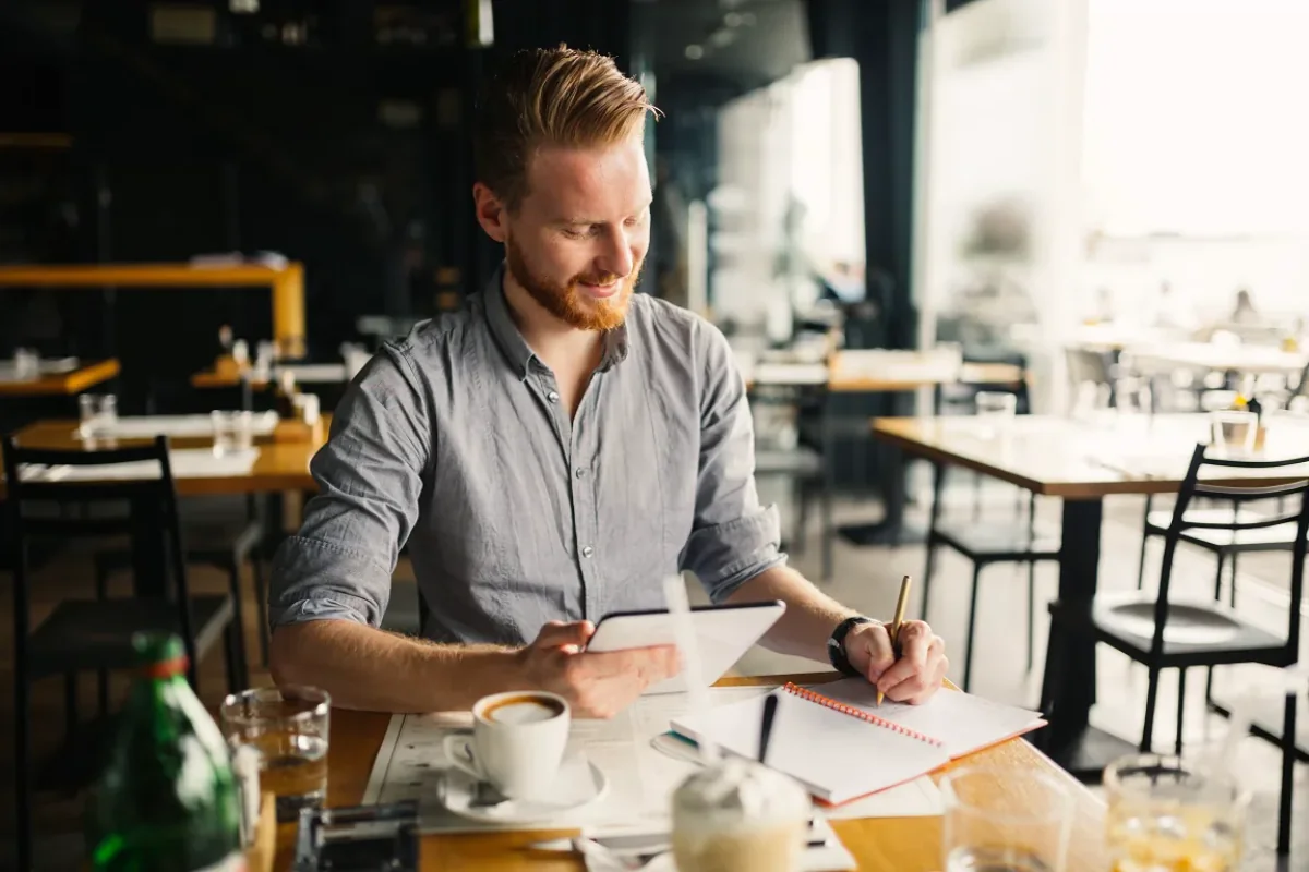 Gérant de café préparant son budget marketing pour une campagne SMS